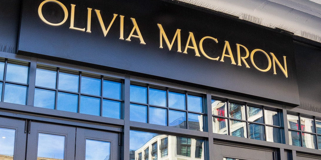 Olivia Macaron store front with large glass doors and reflective surface.