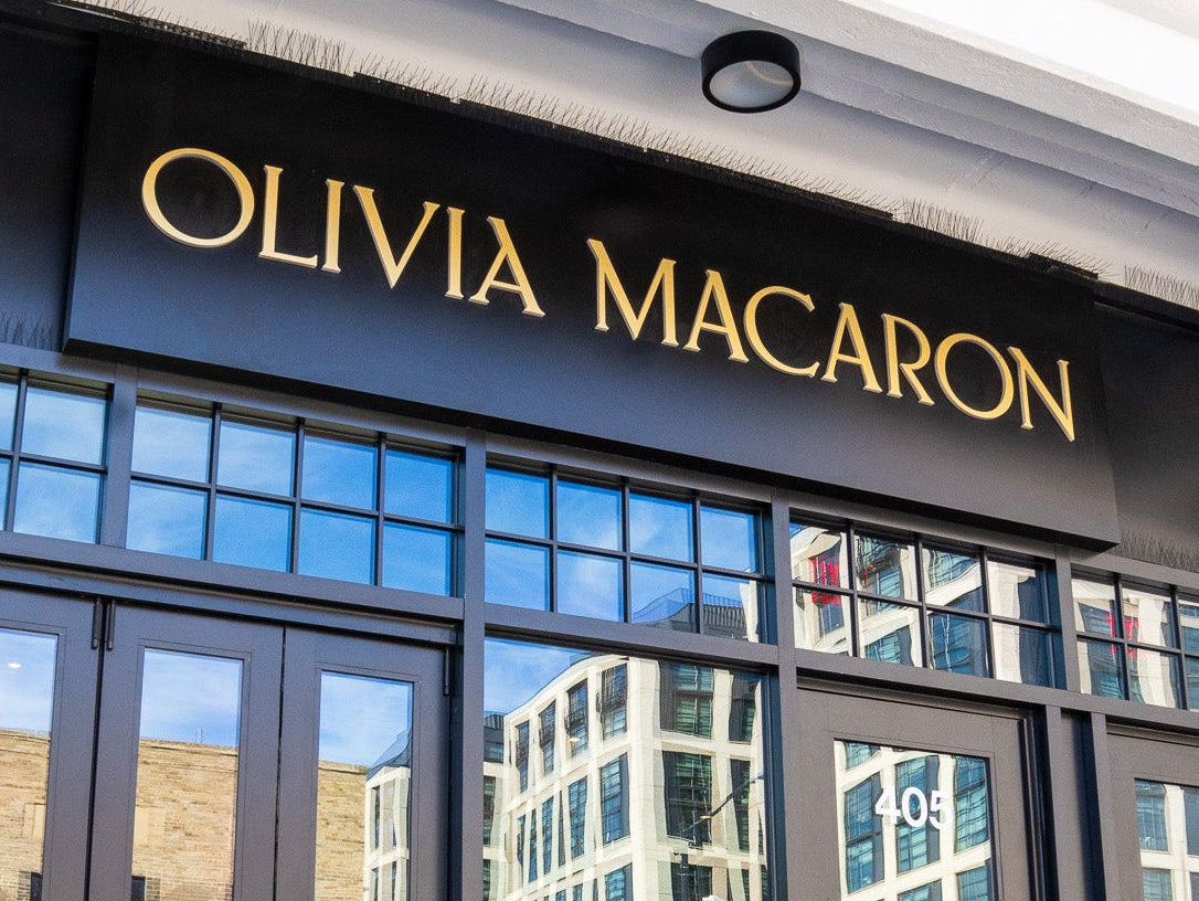 Olivia Macaron store front with large glass doors and reflective surface.