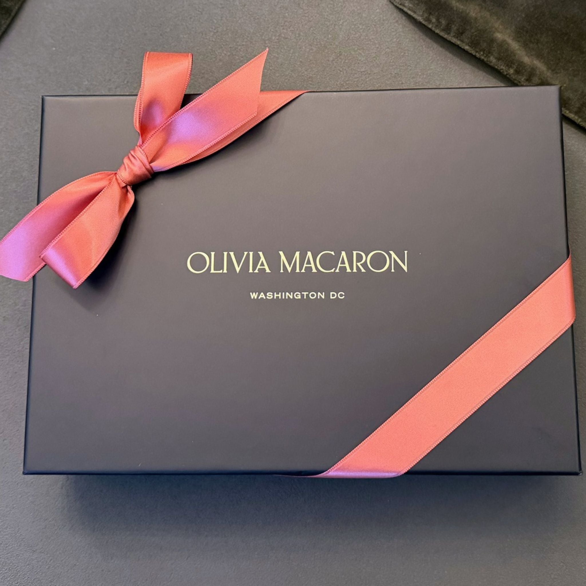 Olivia Macaron black gift box tied with a coral bow